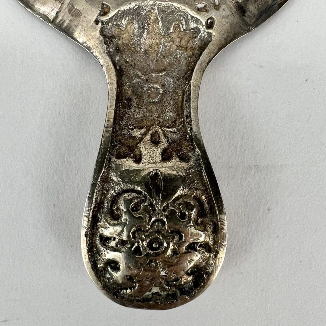 Ornate metal object with floral engravings.