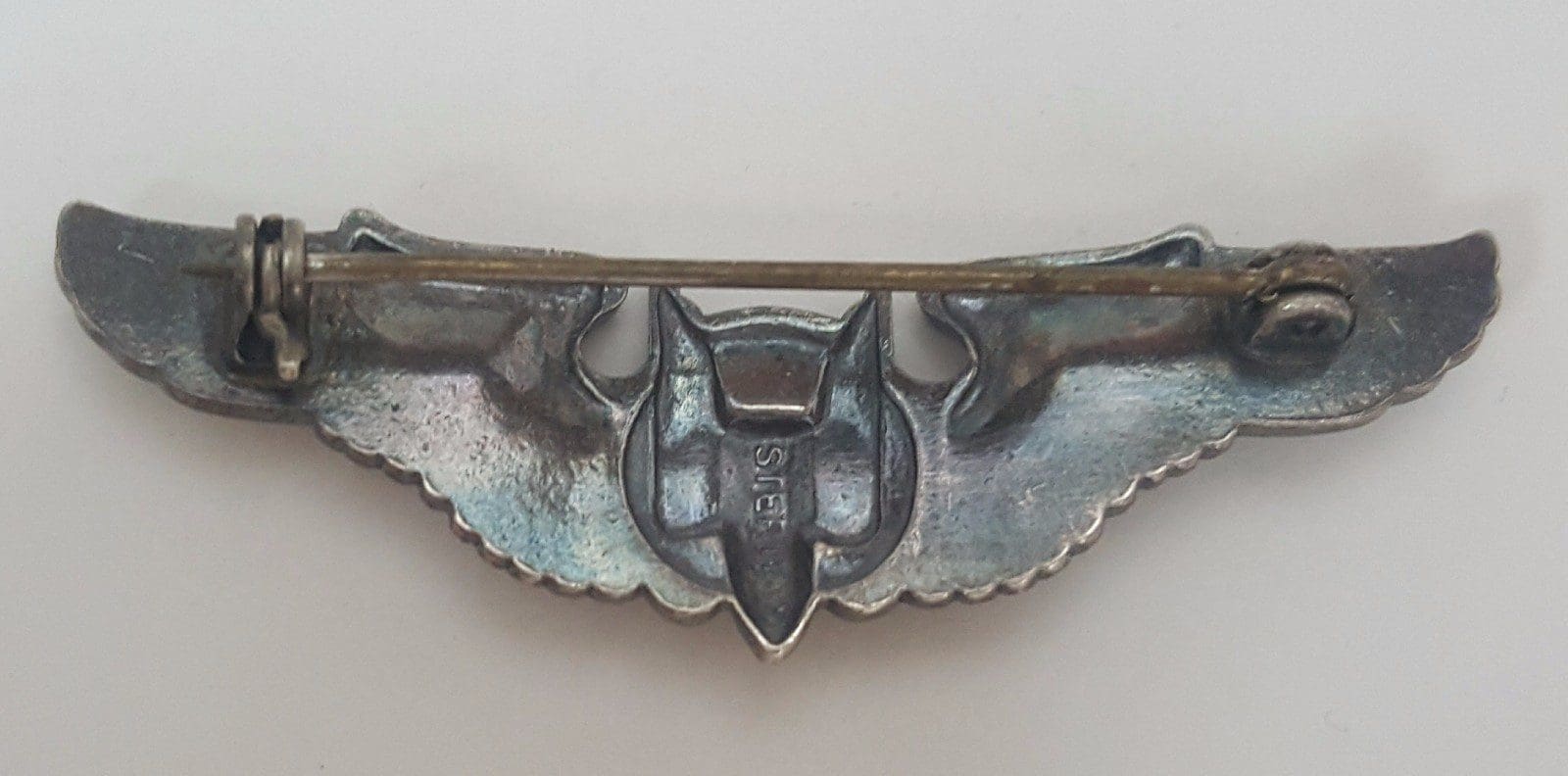Back view of a silver metal pin.
