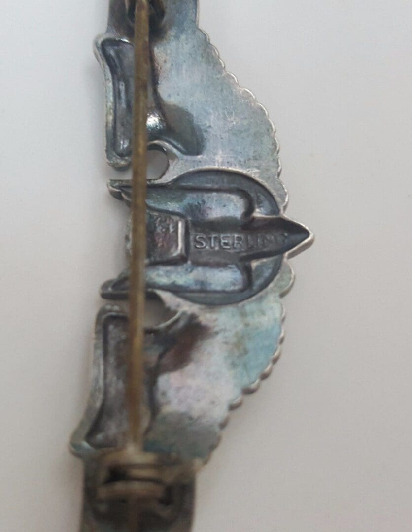 Sterling silver pin with clasp detail.