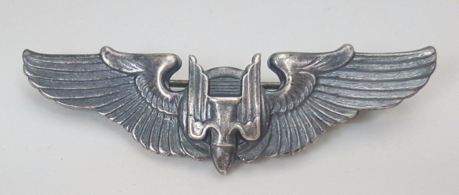 Silver military pilot wings insignia badge.