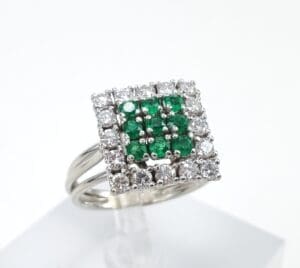 Square diamond ring with green gemstones.