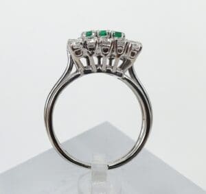 Silver ring with green gemstone details.