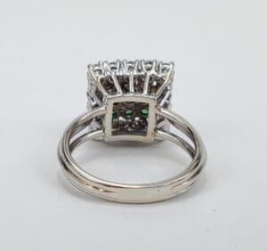 Silver ring with intricate square setting design.