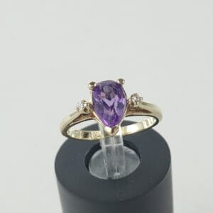 Gold ring with purple gemstone and diamonds.