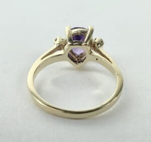 Gold ring with purple gemstone setting.