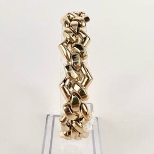 Gold chain bracelet on clear display stand.