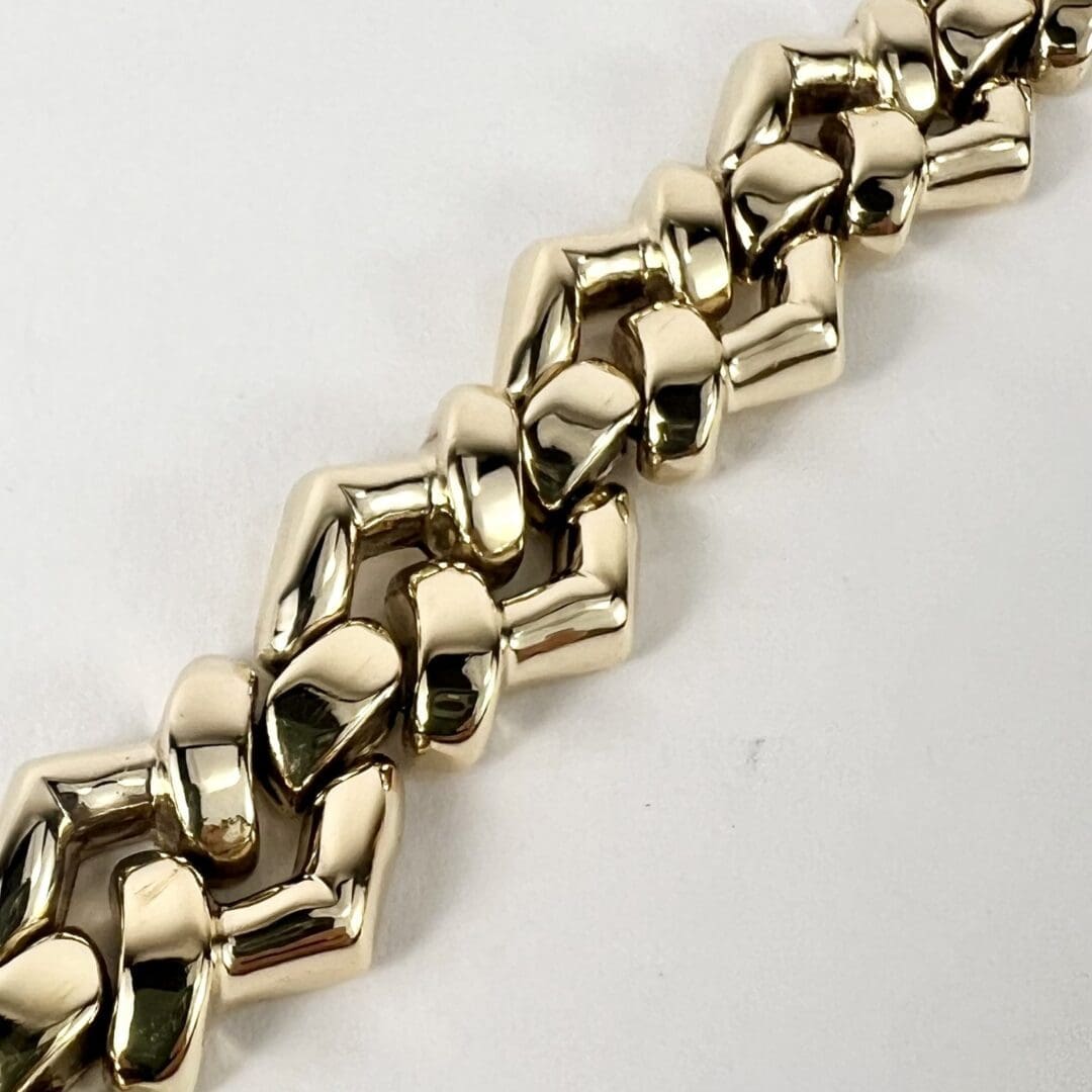 Gold chain bracelet on white background.