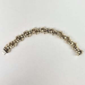 Silver geometric link bracelet on display.