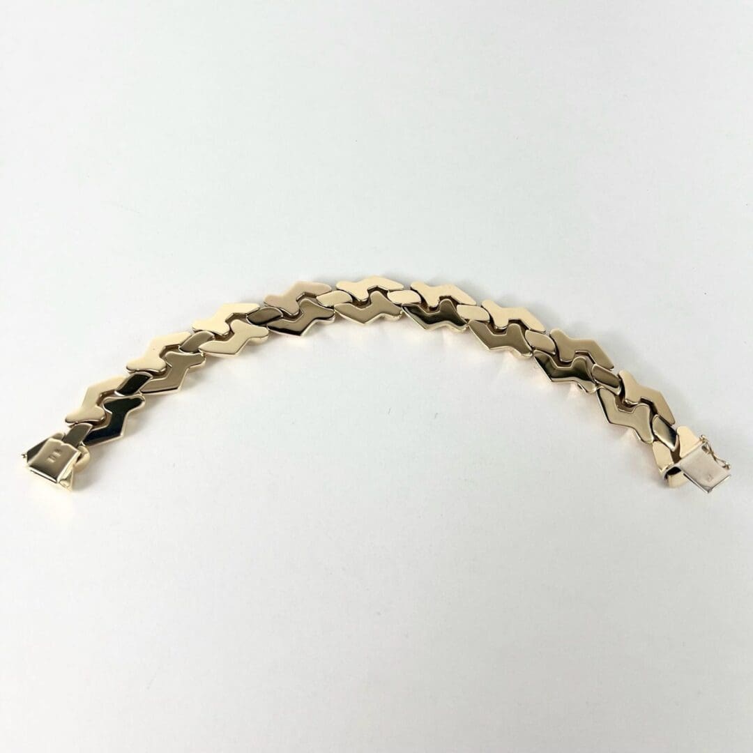 Gold zigzag patterned bracelet on display.