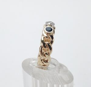 Gold chain ring with diamond and sapphire.