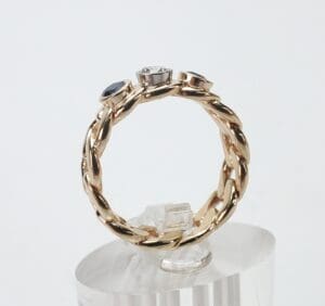 Gold braided ring with three gemstones.