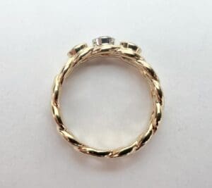 Gold twisted band ring with gemstones.