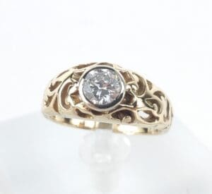 Gold ring with intricate design and gemstone.