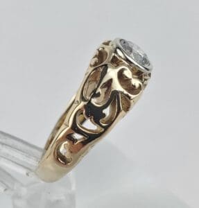 Gold ring with intricate design and gemstone.