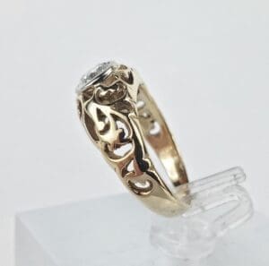 Gold ring with intricate design and gemstone.