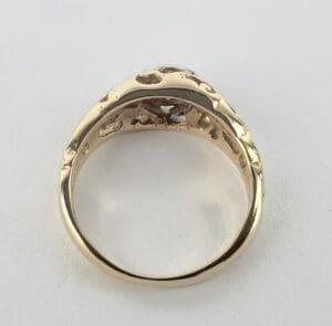 Gold ring with textured design, viewed from side.