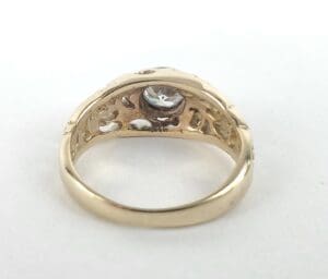 Gold ring with intricate design and gemstone.
