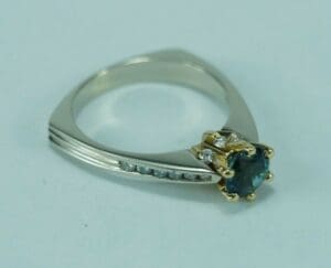 Silver ring with blue gemstone and diamonds.