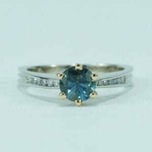 Silver ring with blue gemstone and diamonds.