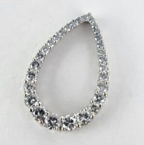 Teardrop-shaped diamond earring on white background.