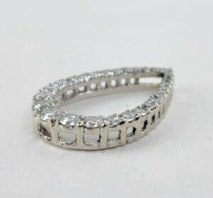 Teardrop-shaped diamond-studded silver jewelry piece.