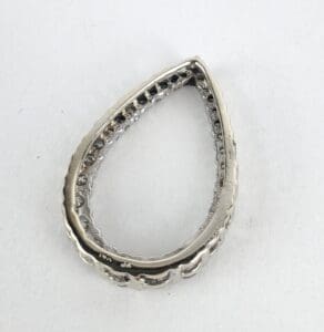 Teardrop-shaped silver jewelry piece on white background.