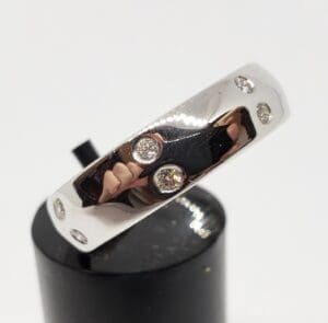 Silver ring with embedded round diamonds.
