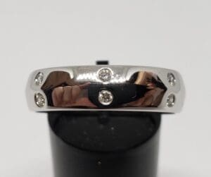 Silver ring with embedded small diamonds.