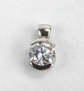 Silver pendant with a large round diamond.
