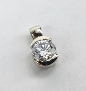 Silver pendant with a round diamond.