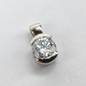 Silver pendant with a round diamond.