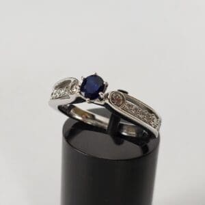 Silver ring with blue gemstone and diamonds.