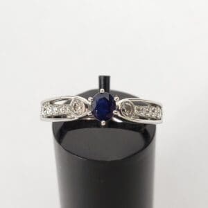 Silver ring with blue center gemstone.