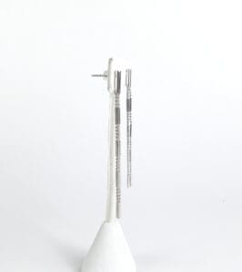 Silver drop earrings on display stand.