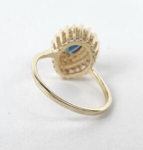 Gold ring with blue gemstone setting.