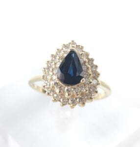 Gold ring with blue and clear gemstones.