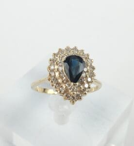 Gold ring with blue gemstone and diamonds.
