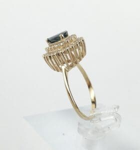 Gold ring with dark gemstone, side view.