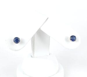 Gold stud earrings with blue gemstones.