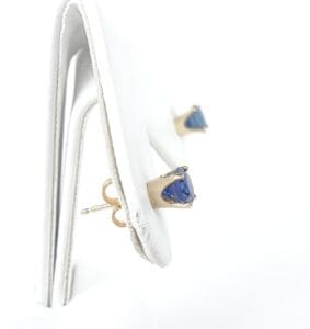 Gold stud earrings with blue gemstones.
