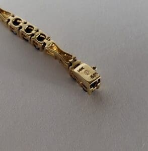 Gold bracelet with detailed clasp design.