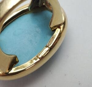 Gold ring with large turquoise stone.