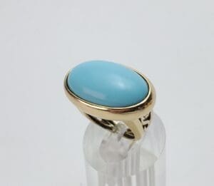 Gold ring with large blue stone.