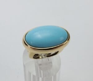 Gold ring with oval turquoise stone.