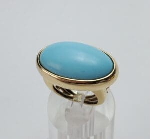 Gold ring with large turquoise stone.