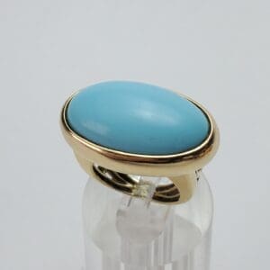 Gold ring with large turquoise stone.