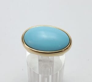 Gold ring with an oval turquoise stone.