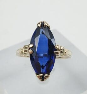 Gold ring with large blue gemstone.