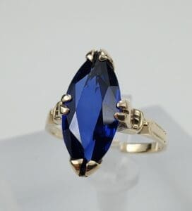 Gold ring with large blue gemstone.