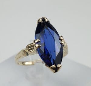Gold ring with large blue gemstone.